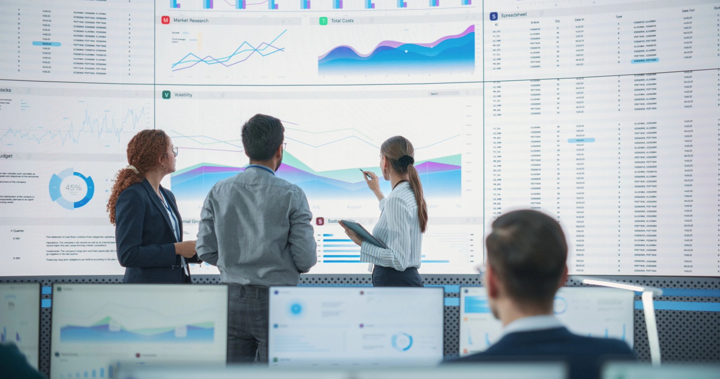 Data scientists reviewing reports on a large screen